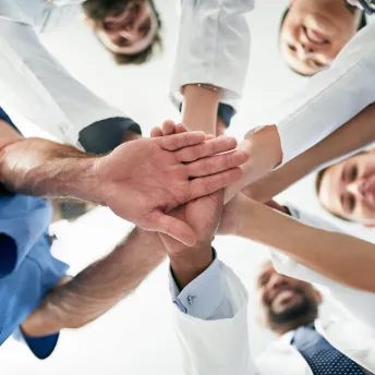 Healthcare professionals joining hands together